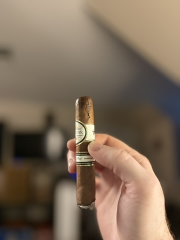 Hand holding a freshly lit Rocky Patel Dark Star Robusto showing a cracked cap.