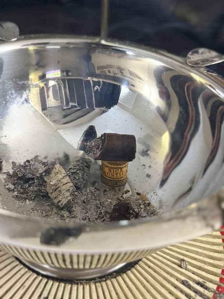 Nica Rustica Connecticut Broadleaf nub resting in a metal ashtray surrounded by ash