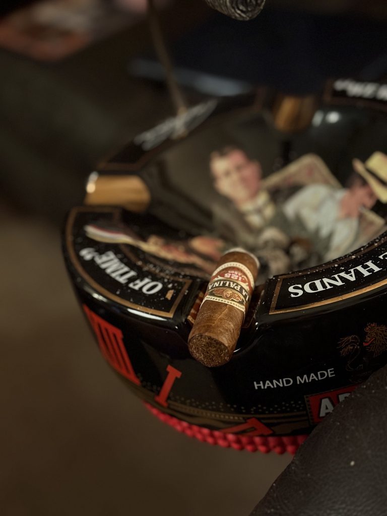 La Palina 125 Años Toro resting in a black ceramic ashtray approximately two-thirds through the smoke with an even burn and clean draw.