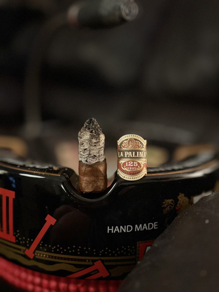 La Palina 125 Años Toro standing upright in an ashtray beside its removed cigar band during the Millennium of Aftermath.
