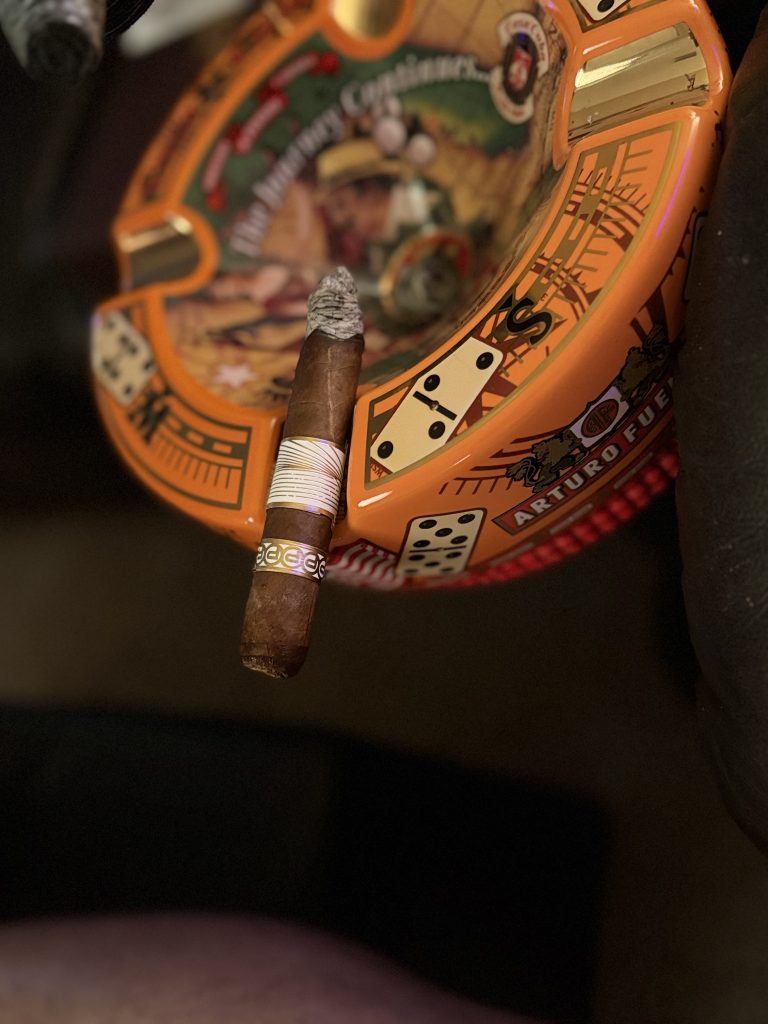 Plasencia Reserva Original Toro resting across an Arturo Fuente “The Journey Continues” ceramic ashtray with a long, well-formed ash during the smoking session.