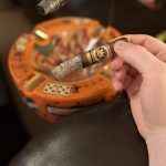 Hand holding the Arturo Fuente Reserva Don Carlos Robusto with an exceptionally long ash.