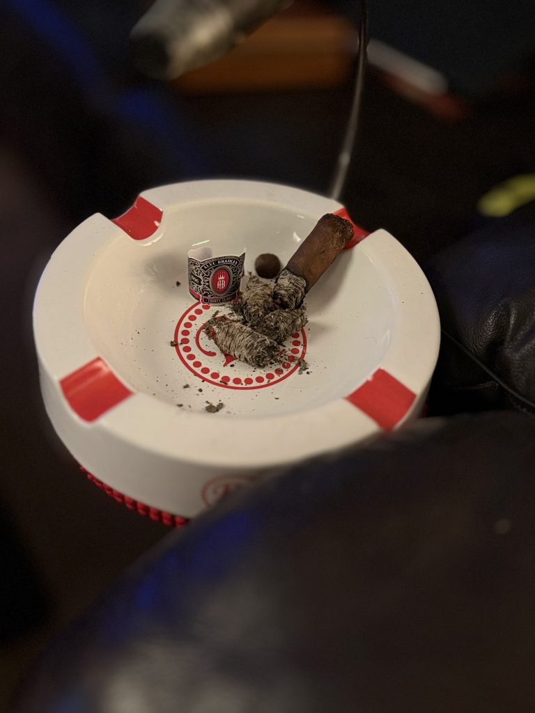 The finished Alec Bradley Thirty Year Toro rests in a white Alec Bradley ashtray after a complete smoking session, showing the final nub and accumulated ash.