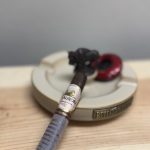 La Aurora Family Creed Fuerte Sol Robusto resting unlit across a Buffalo ashtray with its translucent foot band intact.