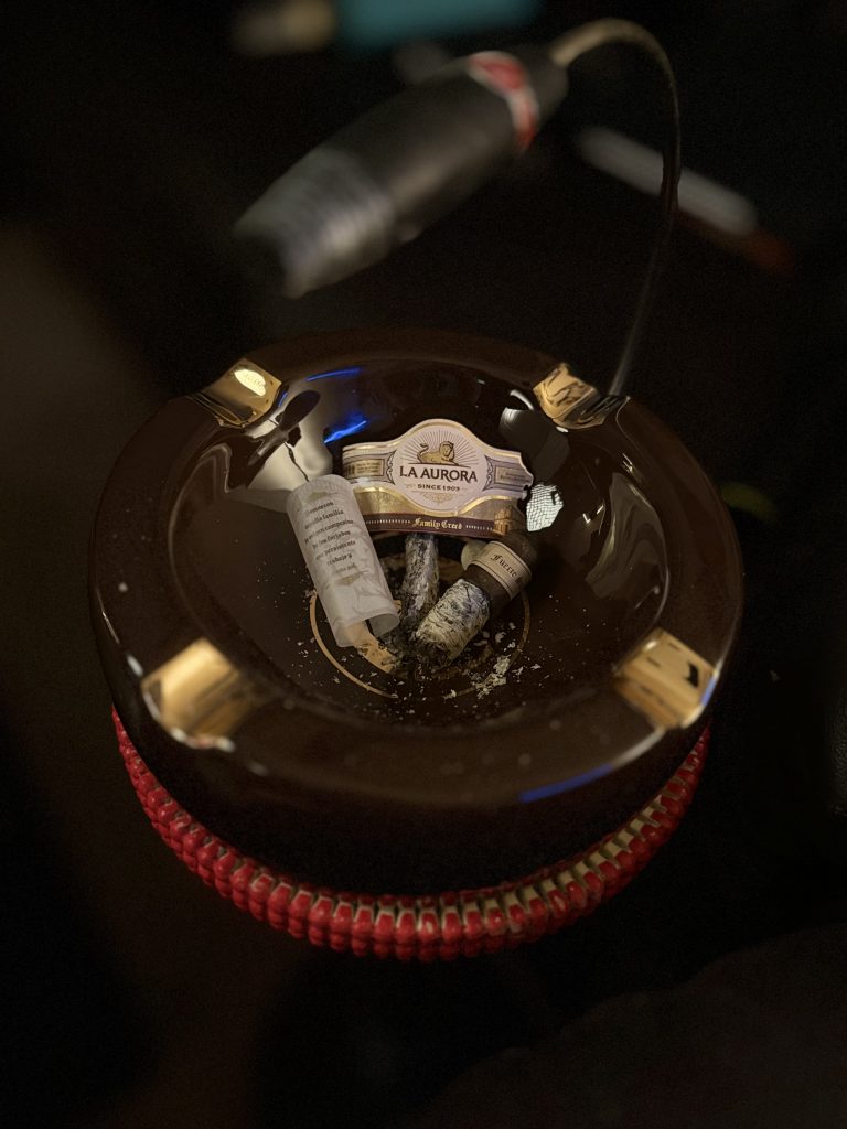 La Aurora Family Creed Fuerte Sol Robusto nub and removed bands inside a brown ashtray after the smoke.