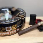 Ashton VSG Sorcerer cigar resting beside a black Arturo Fuente ashtray and black lighter.