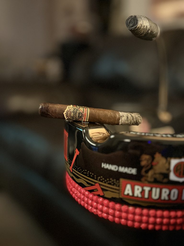 Burning Ashton VSG Sorcerer resting across an Arturo Fuente ashtray in the Evening Draw Lounge.
