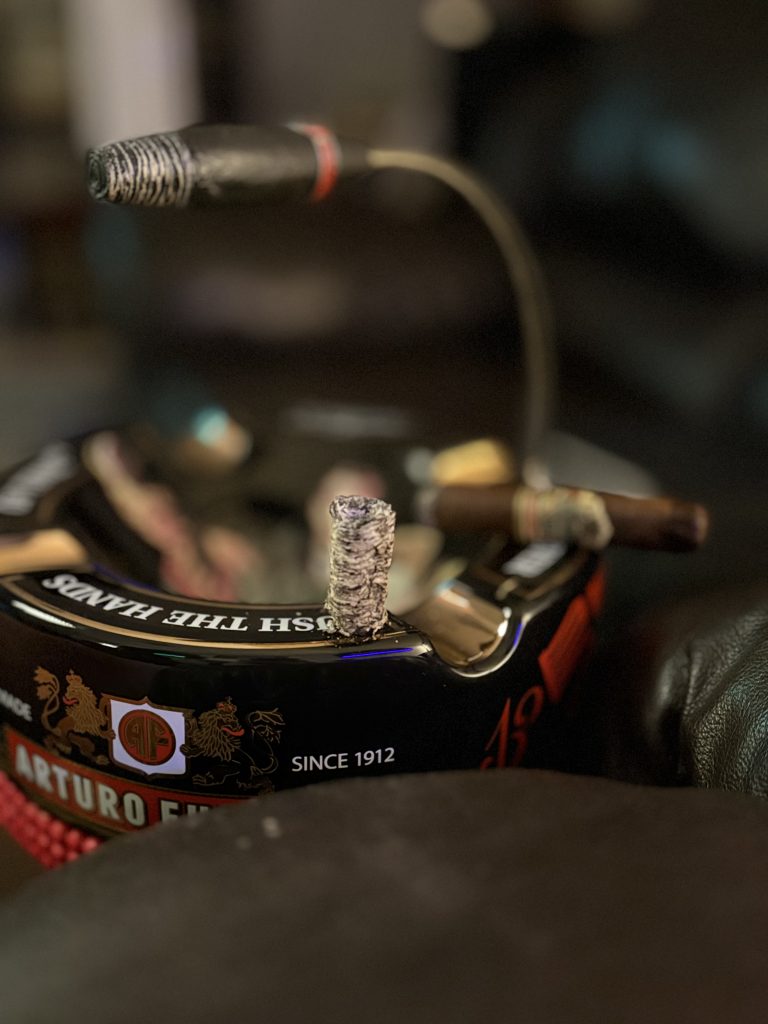 Ashton VSG Sorcerer resting on an Arturo Fuente ashtray as a fallen column of cigar ash balances upright on the rim.