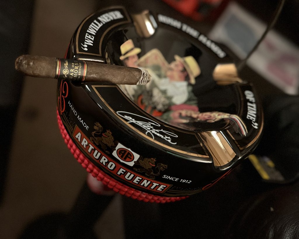 Lit Rocky Patel Year of the Horse Churchill resting across an Arturo Fuente ashtray