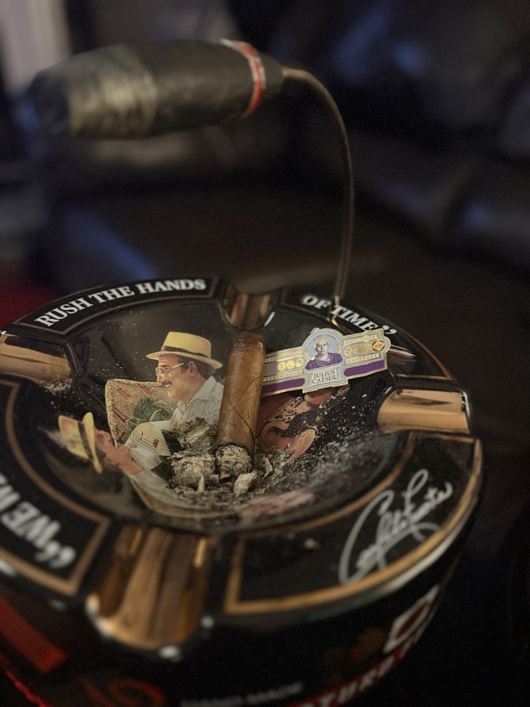 Remains of the Diamond Crown Julius Caeser Toro beside its removed band in an Arturo Fuente ashtray.