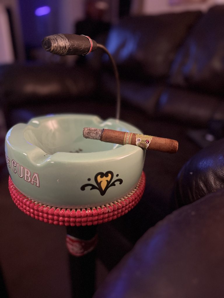 Lit Don Pepin Garcia Vegas Cubanas Toro resting across a green My Father ashtray with a long ash intact.