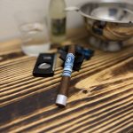 Crowned Heads Moonflower Corona Gorda resting on a black cigar stand beside an Xikar XO cutter and ginger beer in The Evening Draw Lounge.