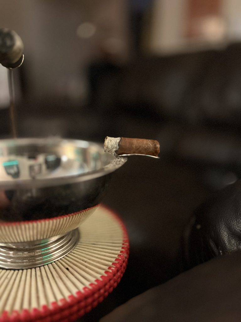Nearly finished Crowned Heads Moonflower Corona Gorda nub resting on a metal ashtray after the cigar bands have been removed.