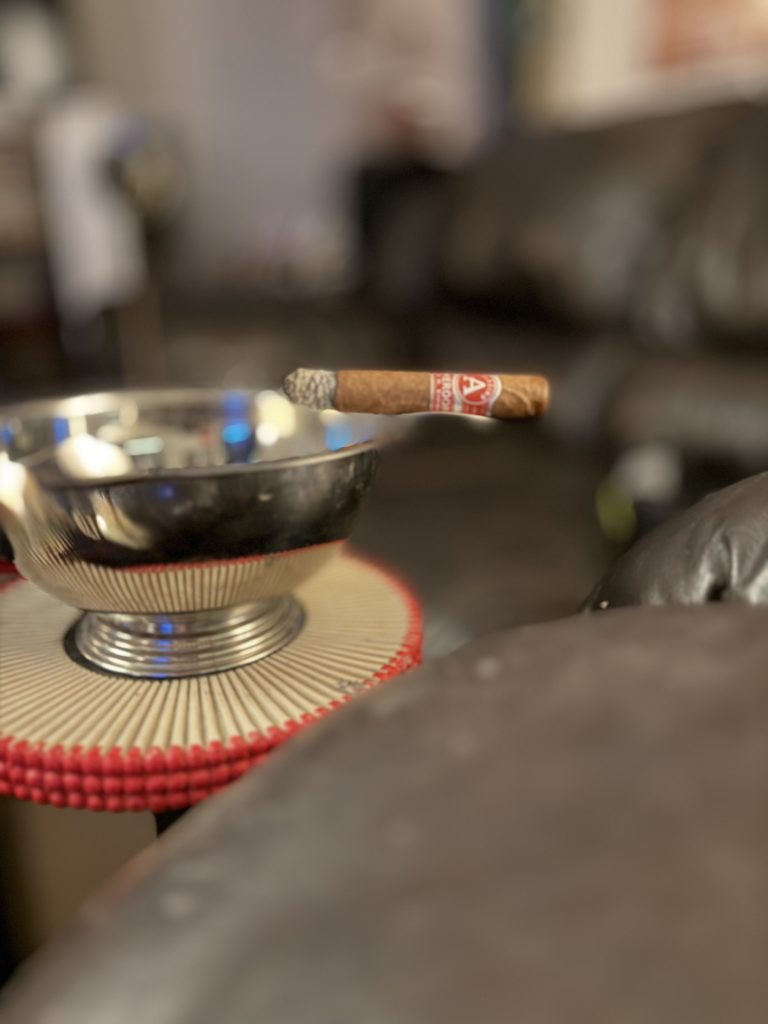 Lit Aladino Cameroon Super Toro resting above a metal ashtray during the smoke.