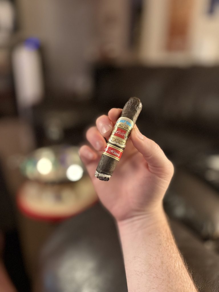 Partially smoked E.P. Carrillo La Historia III held upright with its La Historia and E.P. Carrillo bands visible.