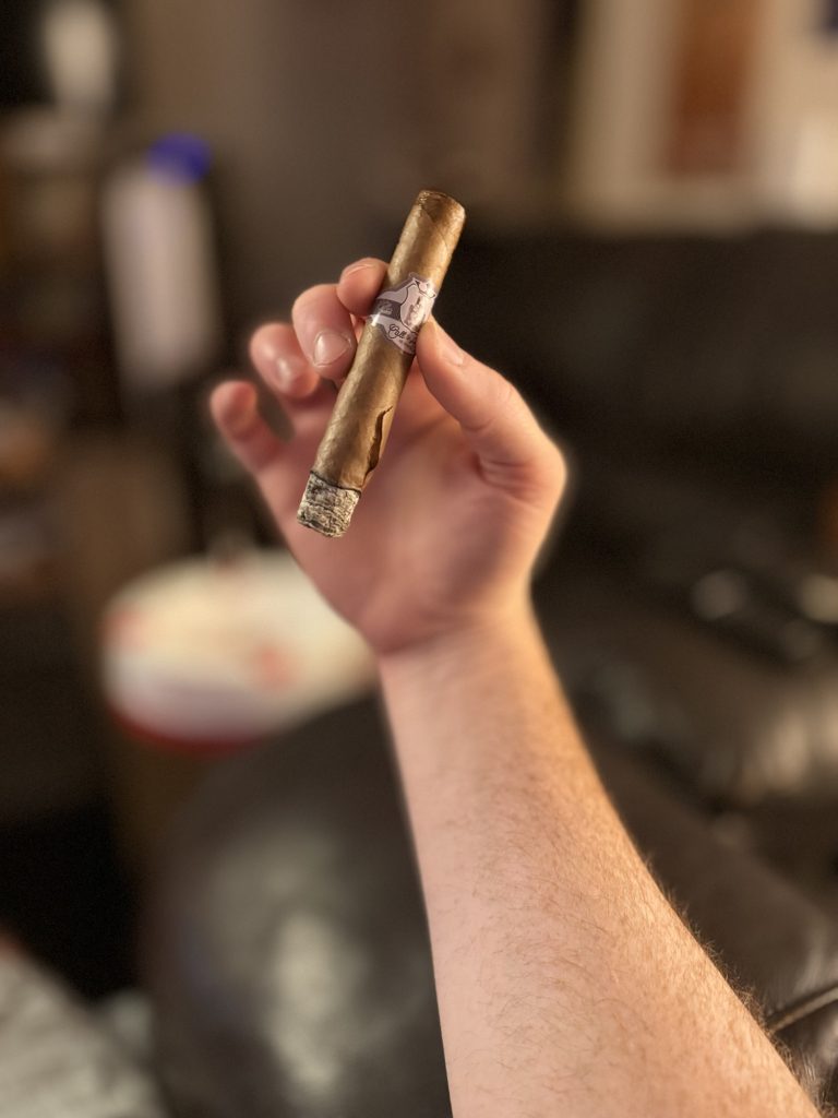 Large wrapper crack on a burning Stolen Throne Call to Arms Sumatra Robusto.
