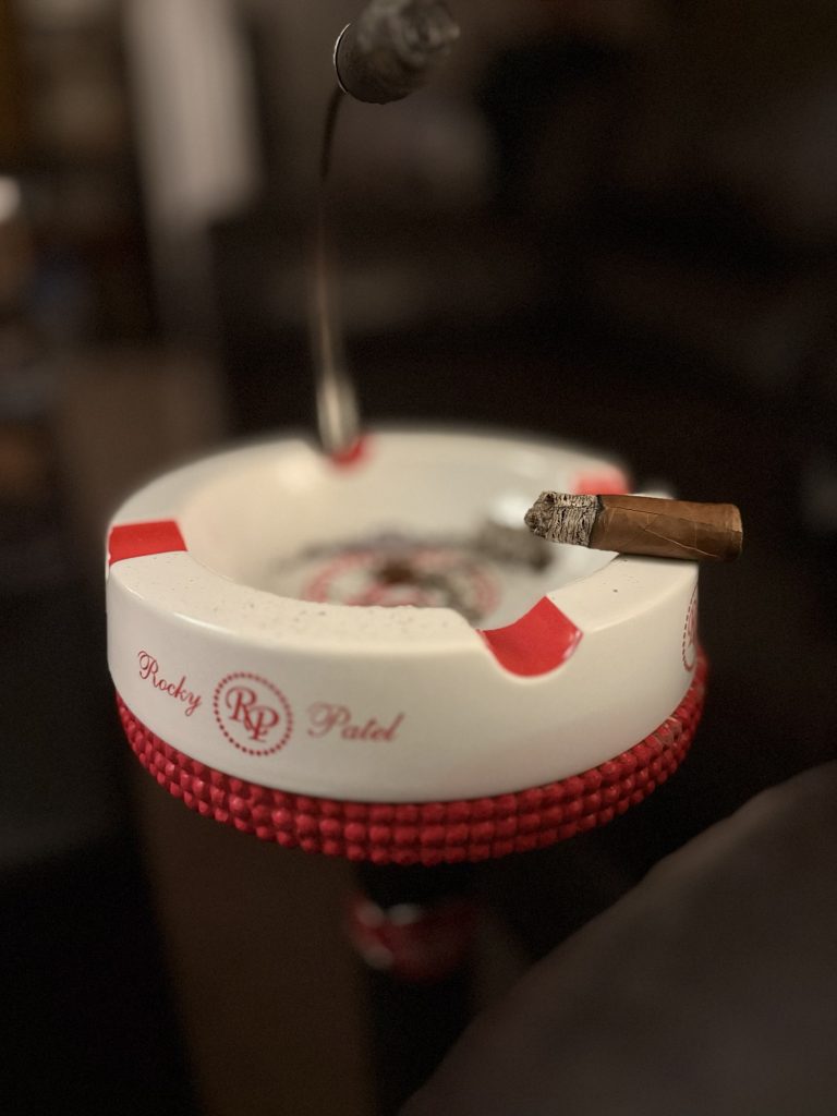 Stolen Throne Call to Arms cigar resting on a Rocky Patel ashtray near the end of the smoke.