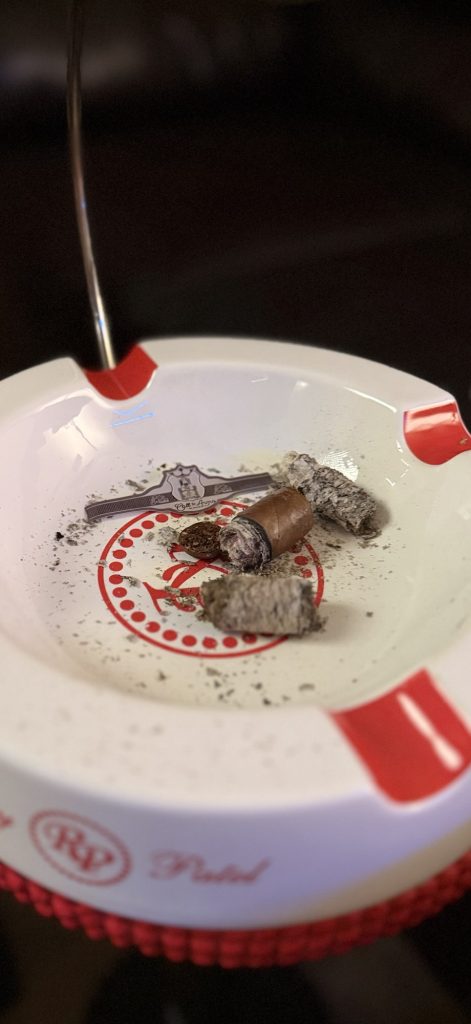 Finished Stolen Throne Call to Arms Robusto nub, ash and removed band in an ashtray.